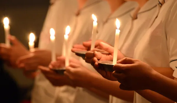 Nursing students hold candles during a capping and pinning ceremony that signifies the brotherhood and sisterhood of nurses.