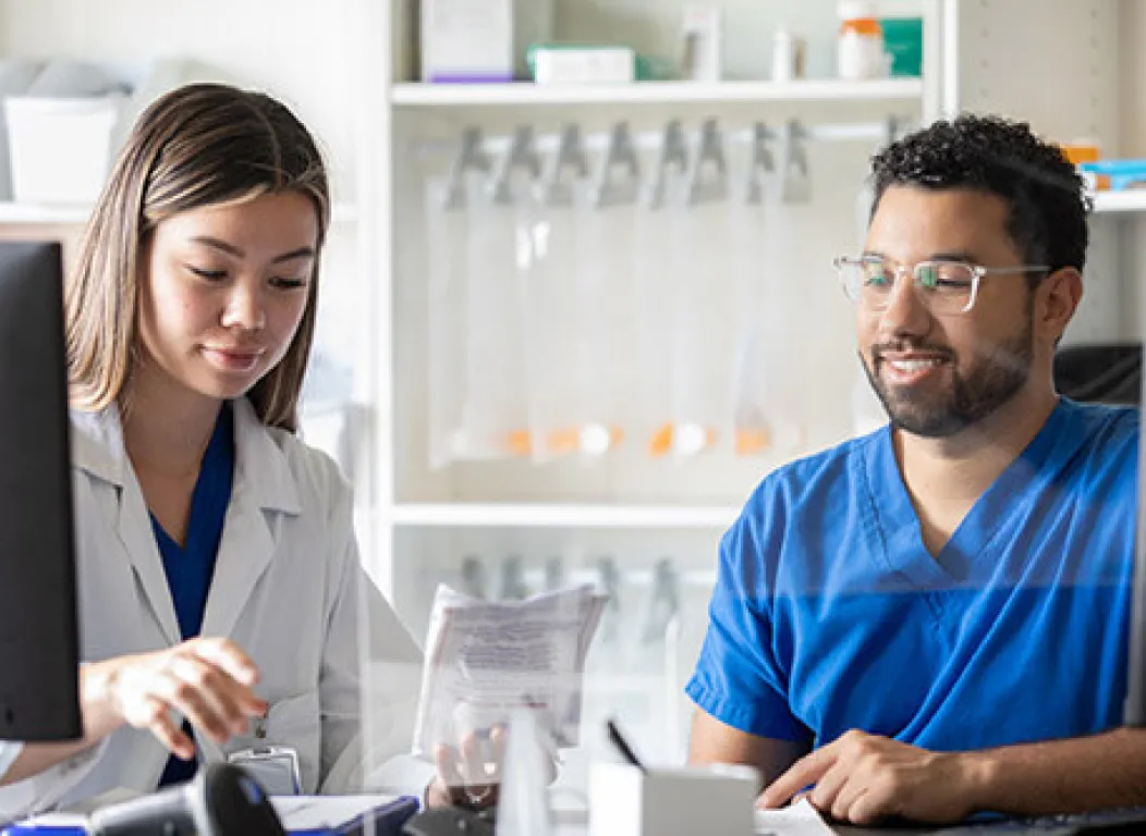 Pharmacy tech assisting pharmacist fill prescription