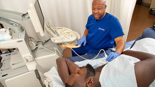 A cardiovascular sonographer performs cardiac ultrasound on patient.