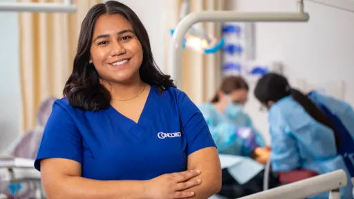 Dental Assistant in scrubs smiles with confidence