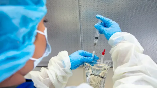 Pharmacy technician preparing medication with syringe and IV bag in sterile environment, showcasing certification skills.