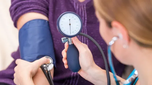 Medical assistant performing a blood pressure check.