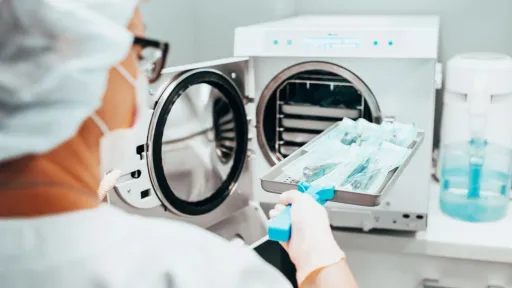 Sterile processing technician placing packaged instruments into an autoclave, representing essential training considerations