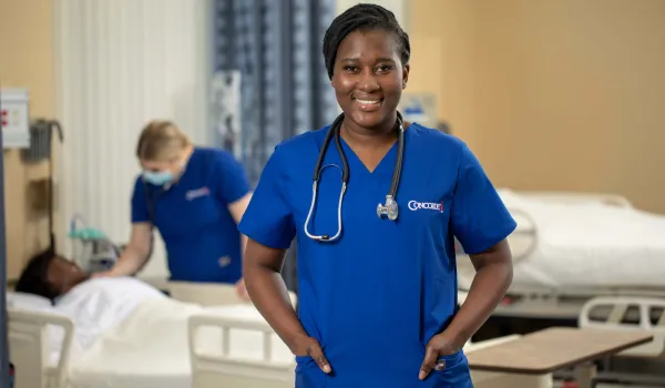 Prelicensure Nursing student standing in front of nurse and patient simulator..