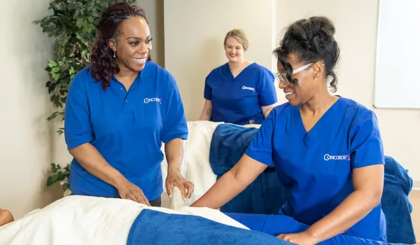 Massage therapy instructor teaching massage therapist about massage on a client.