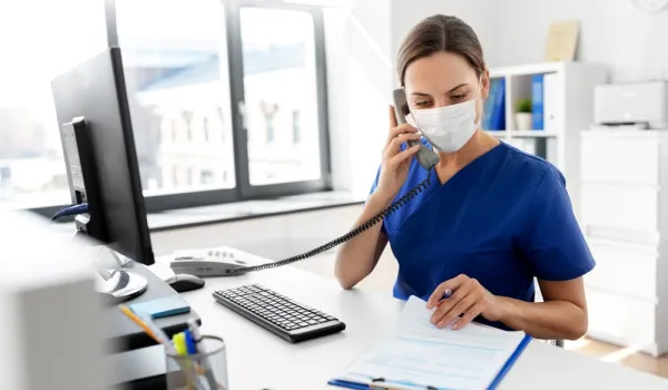 Nurse answering phone at computer