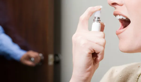 woman spraying breath freshener