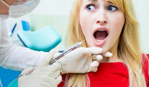 Young patient in dentist office, afraid of anesthetic injection,