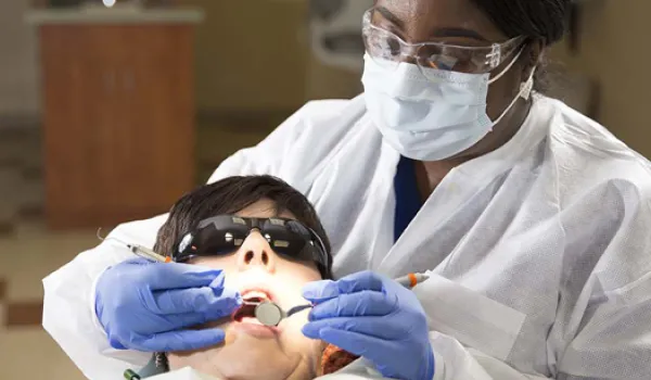 Dental hygienist providing dental care to patient