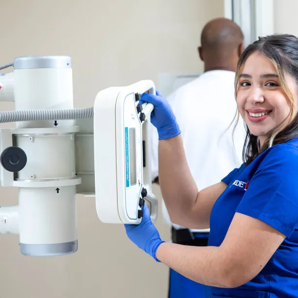 Radiologic Tech demonstrating skills at x-ray machine.