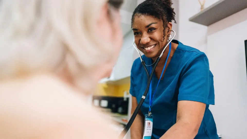 Nurse using a stethoscope during a patient assessment, showcasing clinical responsibilities in nursing.