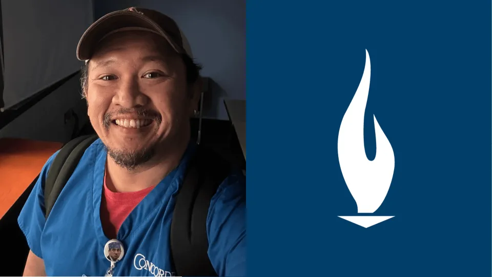 Arnold Septimo wearing blue Concorde scrubs and smiling for the camera